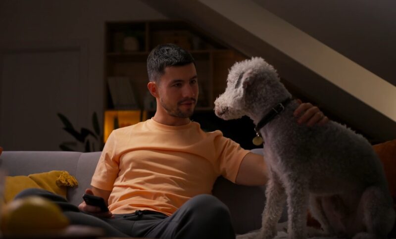 man and dog sitting on couch